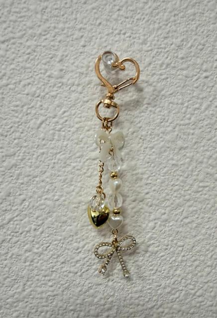 Gold charm with pearly bow, diamond heart, gold heart